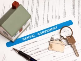 Rental property registration form with keys and a model house on a table