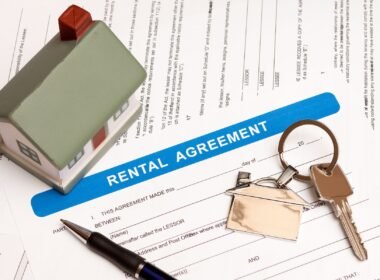 Rental property registration form with keys and a model house on a table