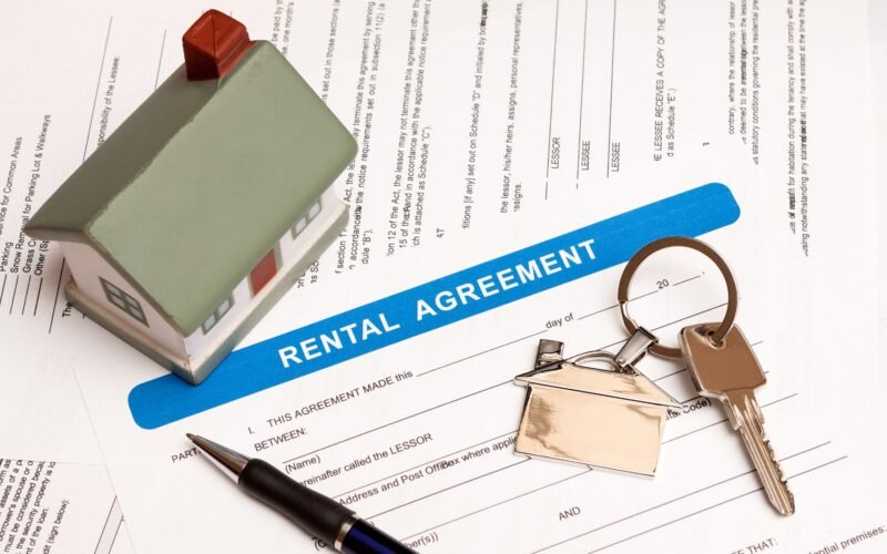 Rental property registration form with keys and a model house on a table